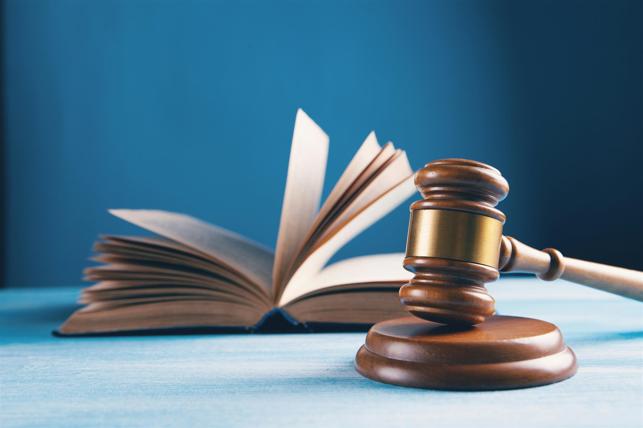 aufgeschlagenes Buch mit Hammer
